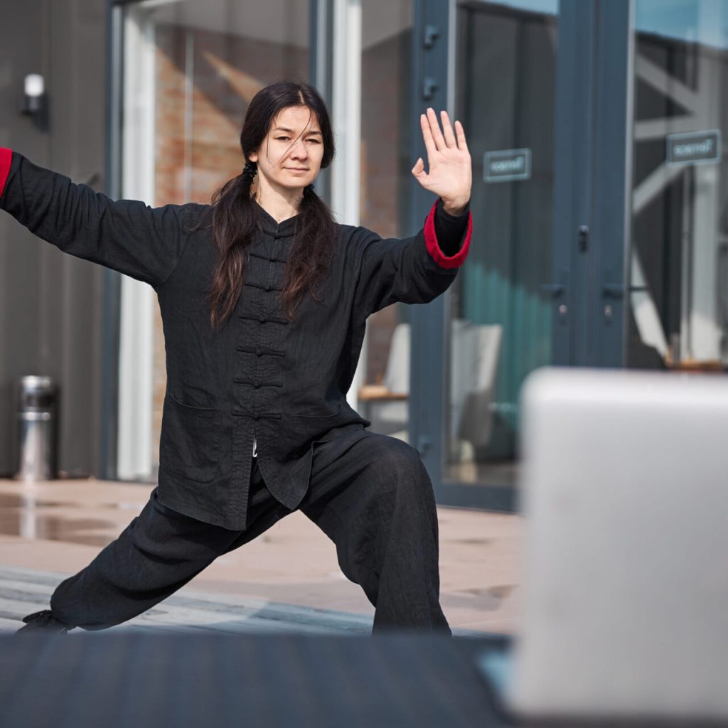 A woman learning Tai Chi in Surrey outside an office